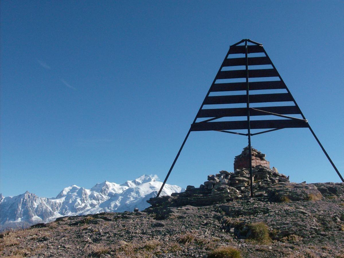 La borne sommitale devant le massif du Mont Blanc.