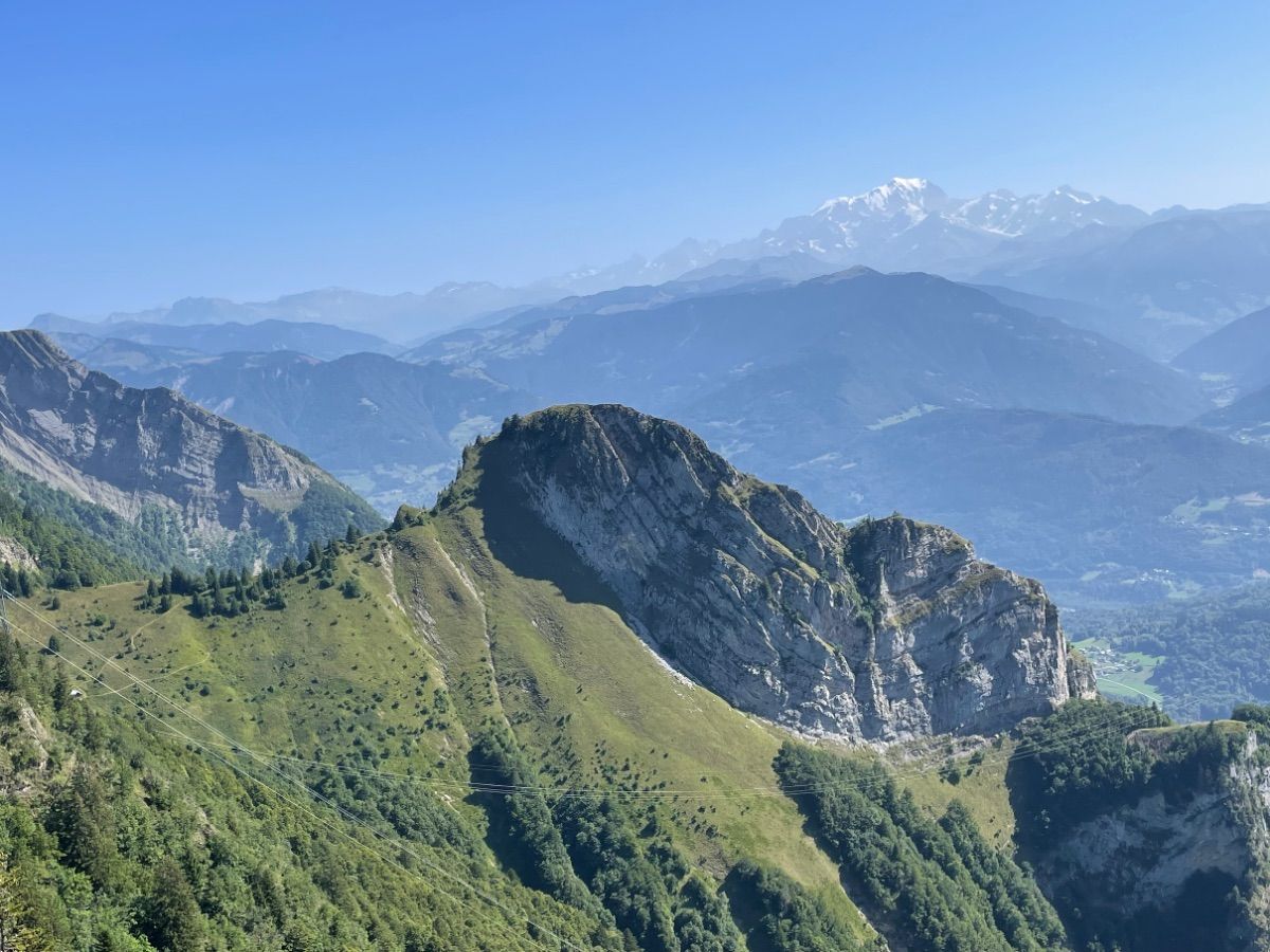 Depuis la Belle Étoile, le Roc Rouge face SE. L’itinéraire longe la falaise puis traverse l’alpage vers la cabane à gauche