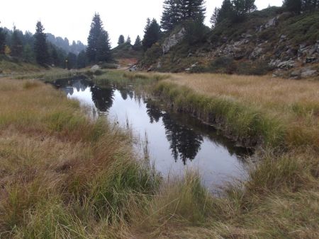 L’ancien sentier de montée démarre au fond à gauche, vers le panneau jaune