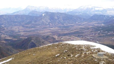 Le sommet, sa borne géodésique et le village de Turriers en bas